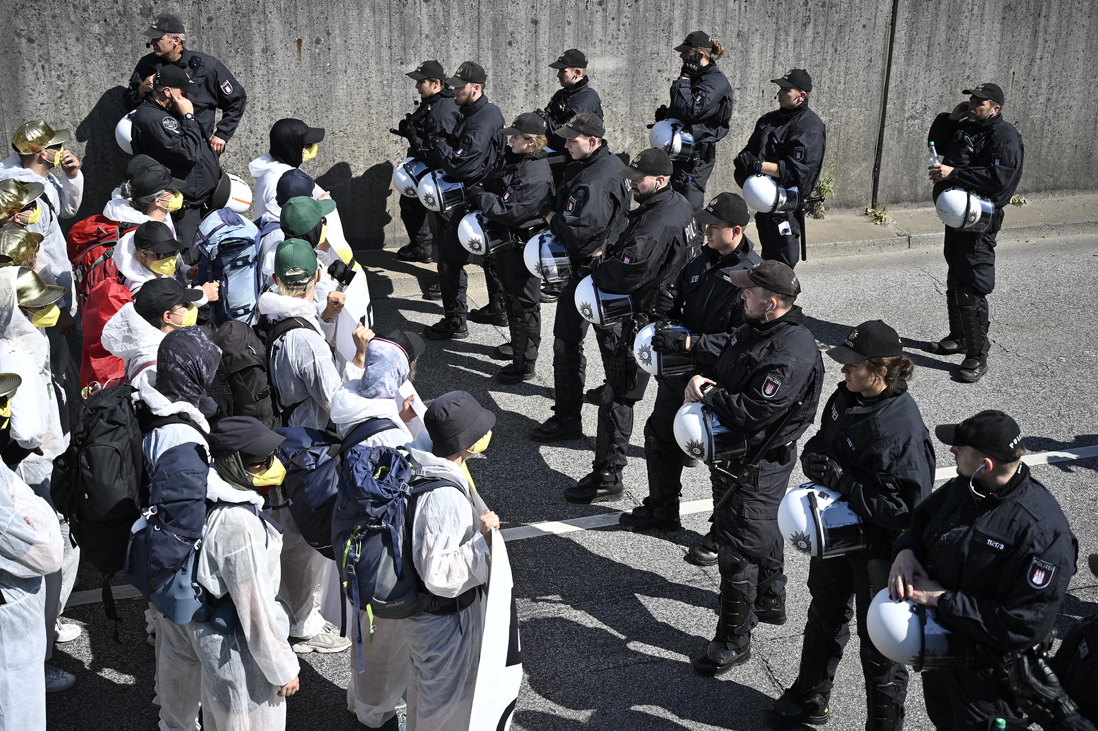 In the picture, a row of policemen* is facing an action finger.