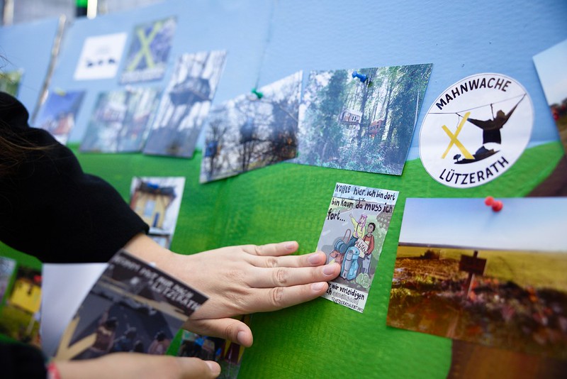 An einer Wand hängen Bilder von Baumhäusern und Aufkleber.